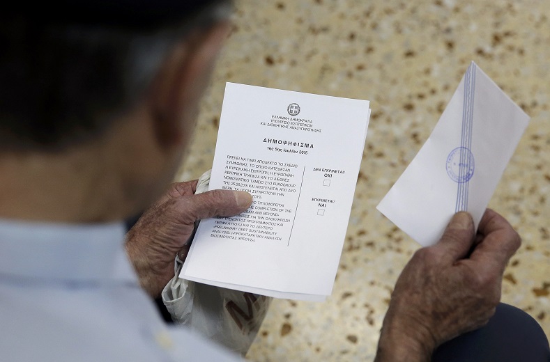 A man checks a ballot before entering a polling booth during a referendum vote in Athens, Greece, July 5, 2015.