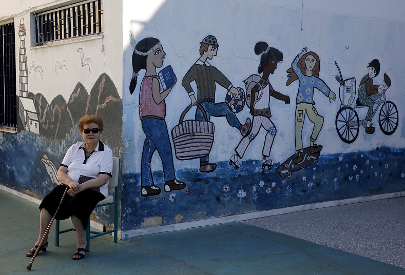 An elderly voter waits outside a polling station at an elementary school in Athens, Greece July 5, 2015.