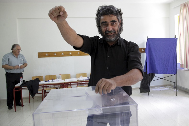 A man gestures as he casts his ballot at a polling station at the village of Anogeia in the island of Crete, Greece July 5, 2015.