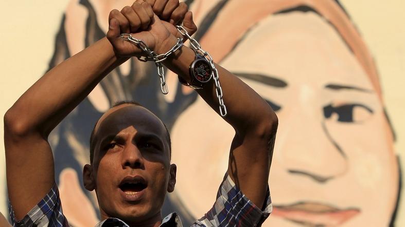 A demonstrator holds up his chained hands as journalists and members of the April 6 movement protest in Cairo against the restriction of press freedom.