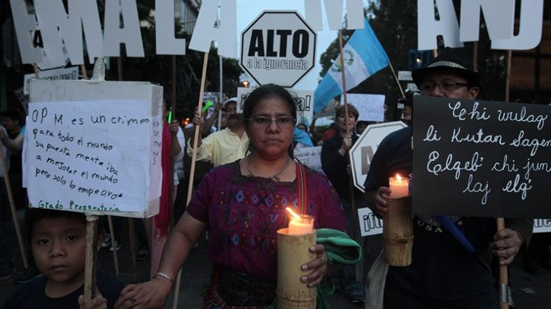 A woman carries a candle during a march to protest government corruption in Guatemala City on July 4, 2015.