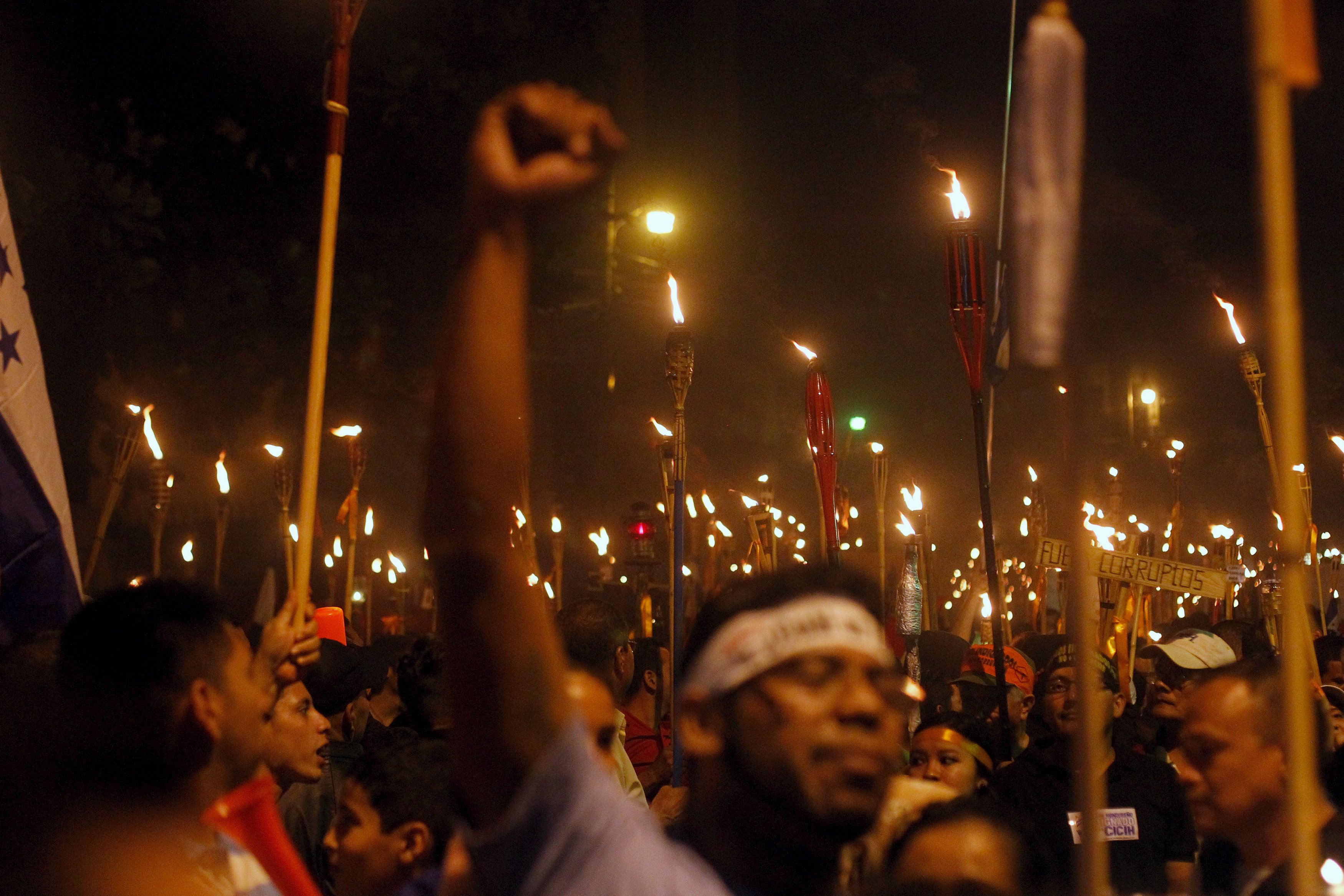 Demonstrators hold torches during a march to demand the resignation of Honduras' President Juan Orlando Hernandez in Tegucigalpa, July 10, 2015