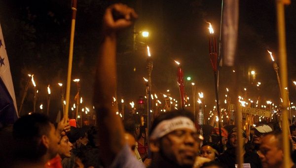 Demonstrators hold torches during a march to demand the resignation of Honduras' President Juan Orlando Hernandez in Tegucigalpa, July 10, 2015