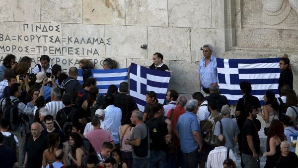 Anti-EU protesters hold Greek flags in front of the monument of the unknown soldier by the parliament building during a demonstration of about five hundred people in Athens, Greece July 13, 2015.