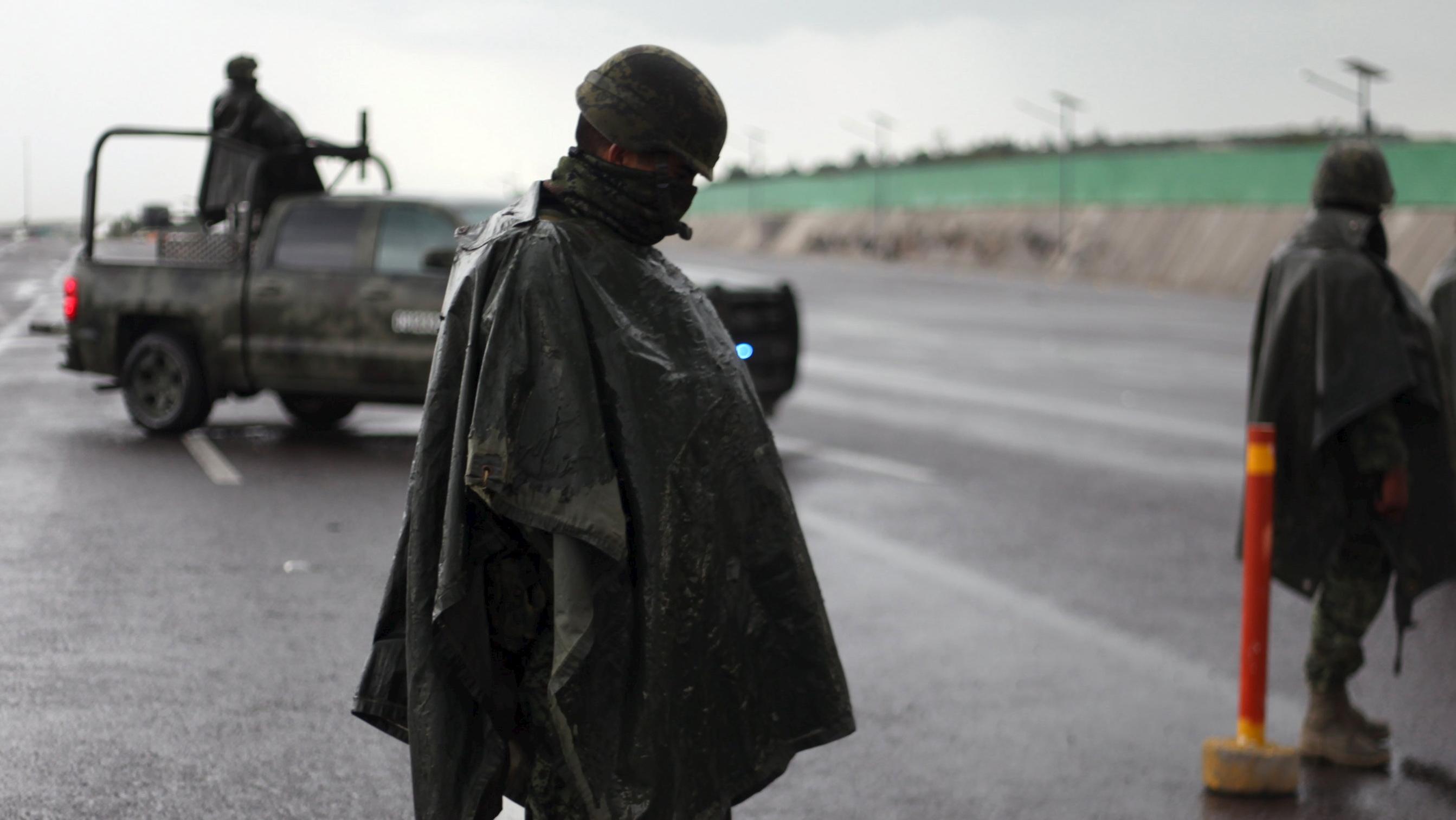 Soldiers stand guard at a checkpoint on a highway in Contepec, in Michoacan state, July 12, 2015.