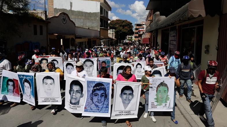 Relatives hold pictures of missing students in Guerrero last year.
