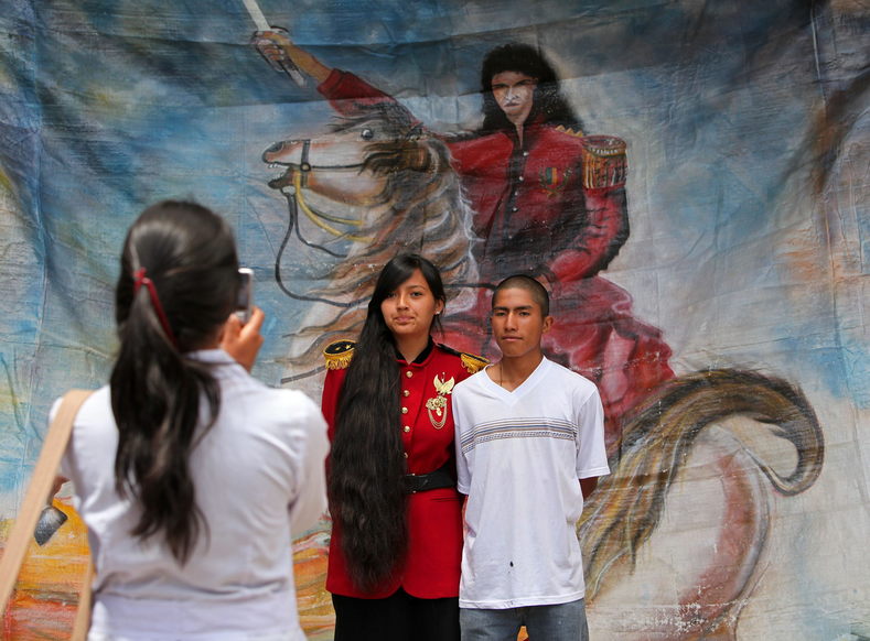 Bolivian students from the Juana Azurduy de Sucre school have their photo taken in front of an image of their heroine, in this March 2010 file photo.