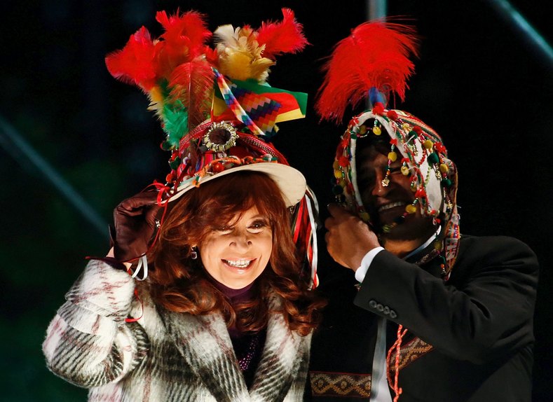 Argentina's president Cristina Fernandez (L) and her Bolivian counterpart Evo Morales (R) put on typical Bolivian hats during a ceremony outside the Casa Rosada Presidential Palace in Buenos Aires, July 15, 2015.