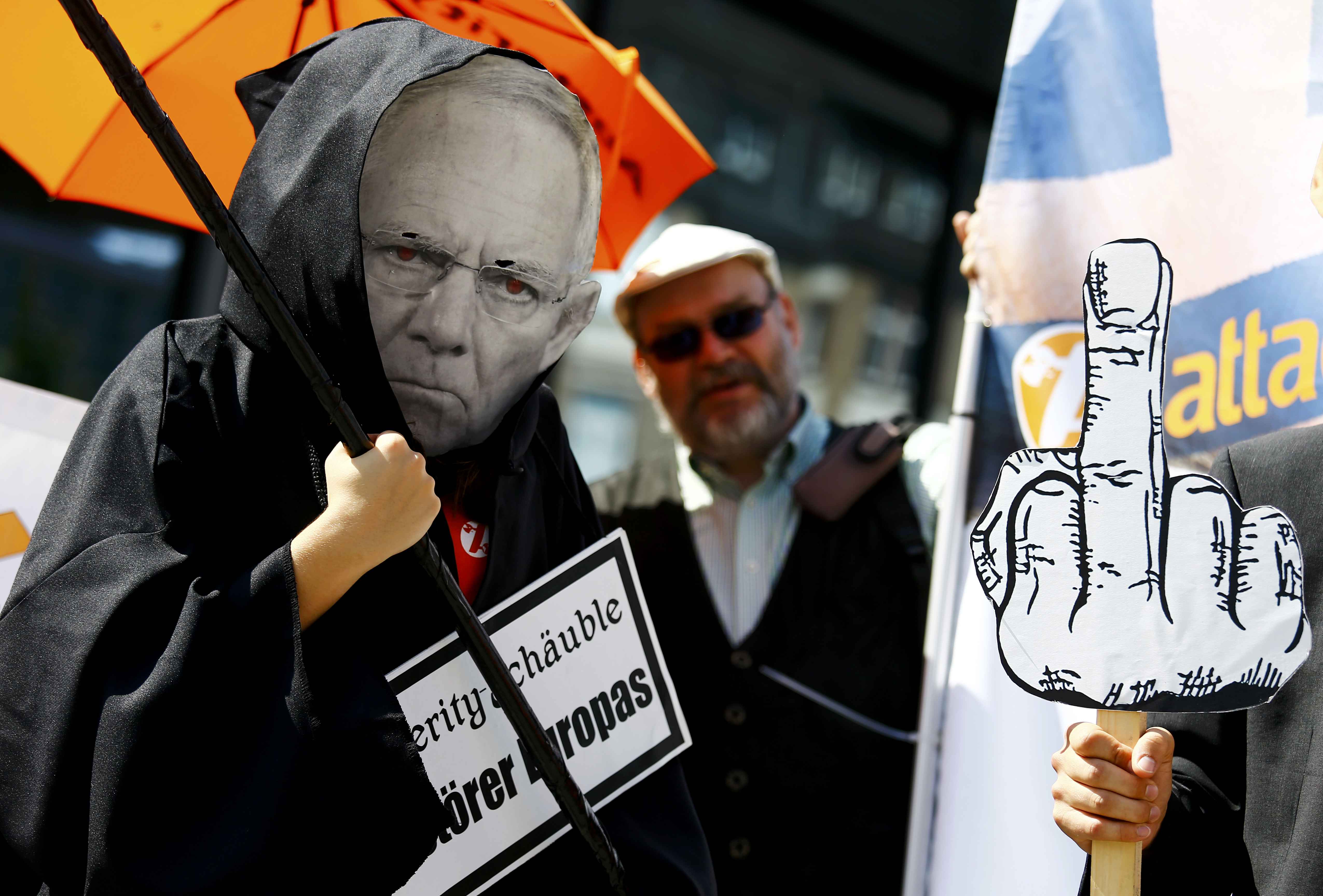 A demonstrator wearing the mask depicting German Finance Minister Wolfgang Schaeuble takes part in a protest outside the European Central Bank headquarters in Frankfurt, Germany, July 16, 2015.
