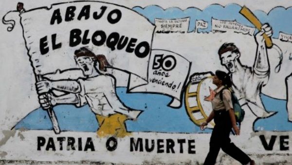 A pedestrian walks past graffiti in Cuba that read 
