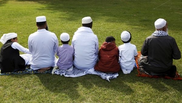 A Muslim family perform prayers for Eid-al Fitr to mark the end of the holy fasting month of Ramadan at a park in London, Britain, July 17, 2015.