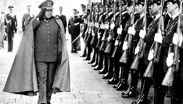 Former Chilean dictator General Augusto Pinochet reviews troops as he enters La Moneda Palace in the capital Santiago