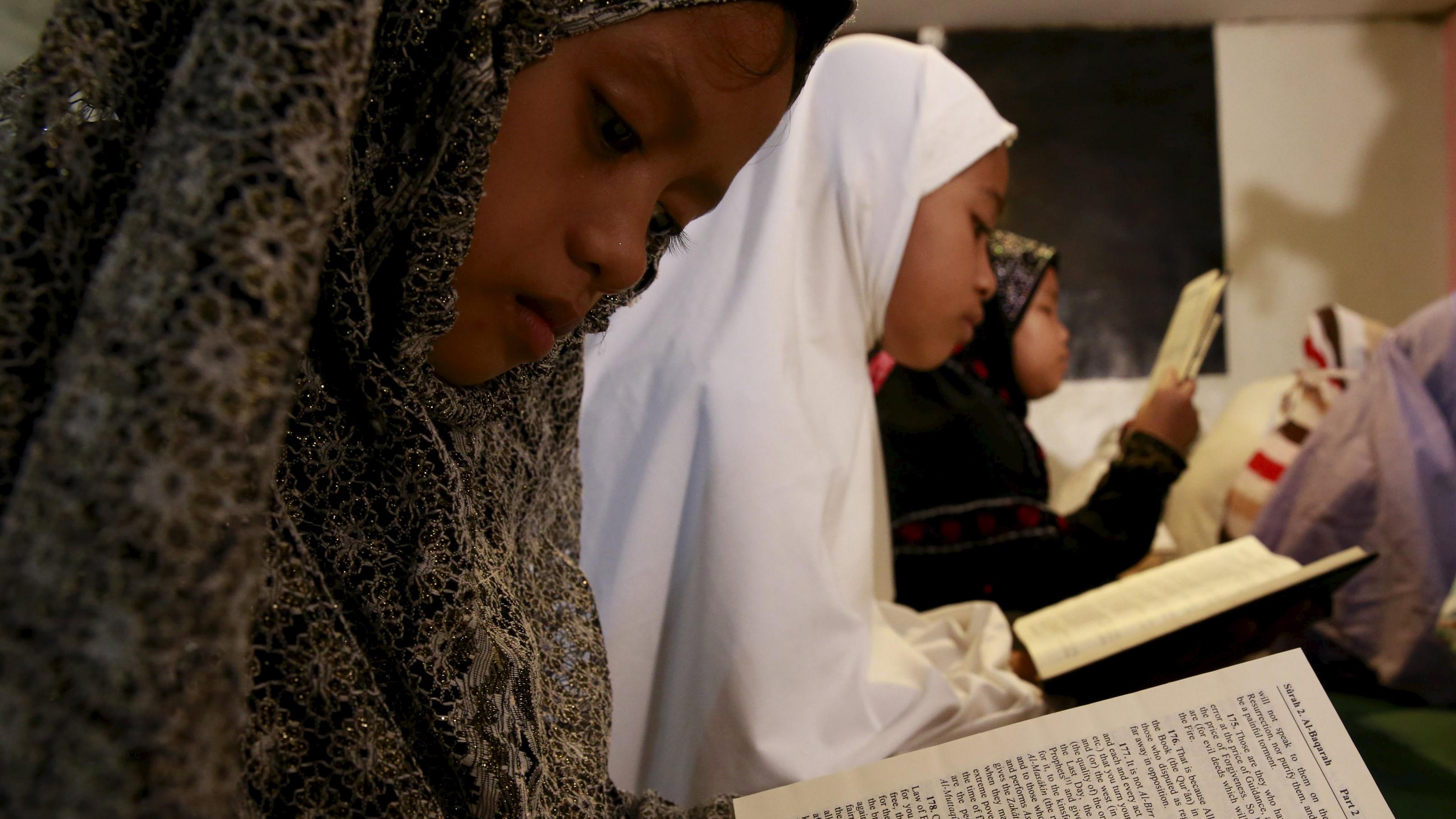 Muslim children read the Quran as they study inside a mosque at a slum area in Baseco, Tondo, metro Manila July 10, 2015.
