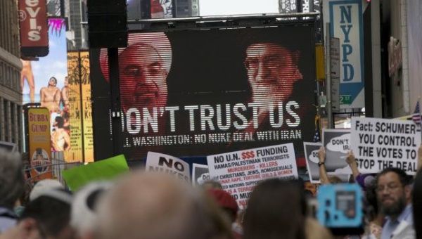 An image of Iranian leaders is projected on a giant screen in front of demonstrators during a rally apposing the nuclear deal with Iran in Times Square, New York City, July 22, 2015.