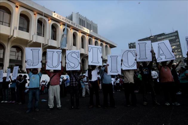 Protesters gather outside the Guatemalan Supreme Court with signs that read, 'Justice'