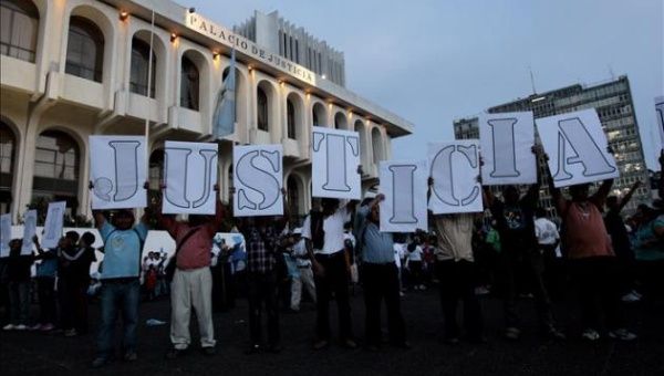 Protesters gather outside the Guatemalan Supreme Court with signs that read, 'Justice'