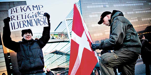 Danish protesters hold the Danish flag and an anti-religious sign that says “Fight religious brainwashing.”