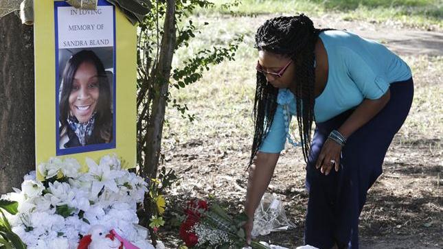 A woman lays flowers for Sandra Bland, who was found dead in police custody on July 13.
