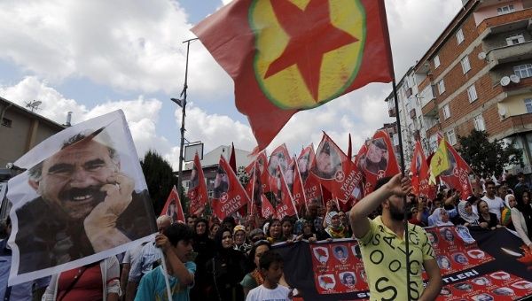 People in Turkey march with the pictures of people killed by bomb attacks in Suruc, as well as a picture of Abdullah Ocalan (L) and PKK flags, July 22, 2015.
