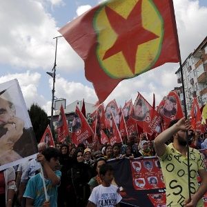 People in Turkey march with the pictures of people killed by bomb attacks in Suruc, as well as a picture of Abdullah Ocalan (L) and PKK flags, July 22, 2015.