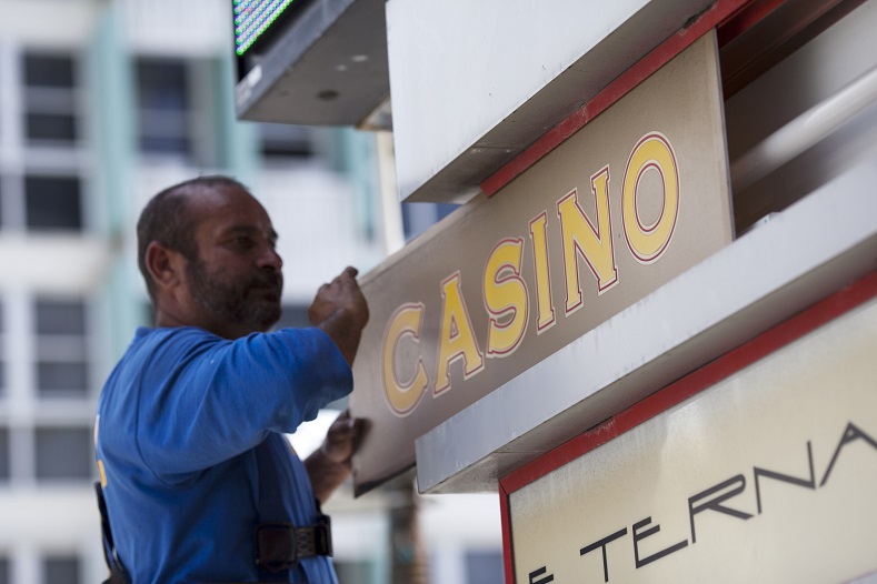 A worker removes the casino sign of the Condado Plaza Hotel after a spokesman announced that the casino is closing, in San Juan, Puerto Rico July 22, 2015. 