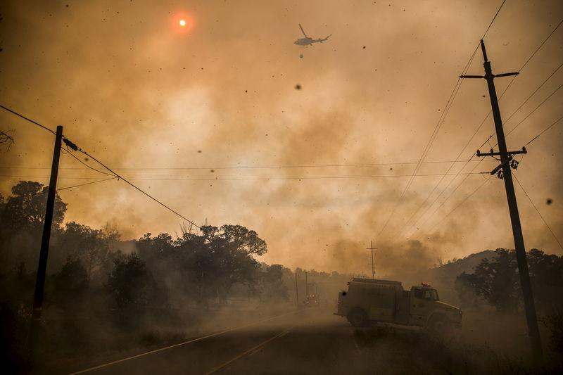 Firefighters on the ground and in the air scramble to battle spot fires at the Rocky Fire in Lake County, July 30, 2015.