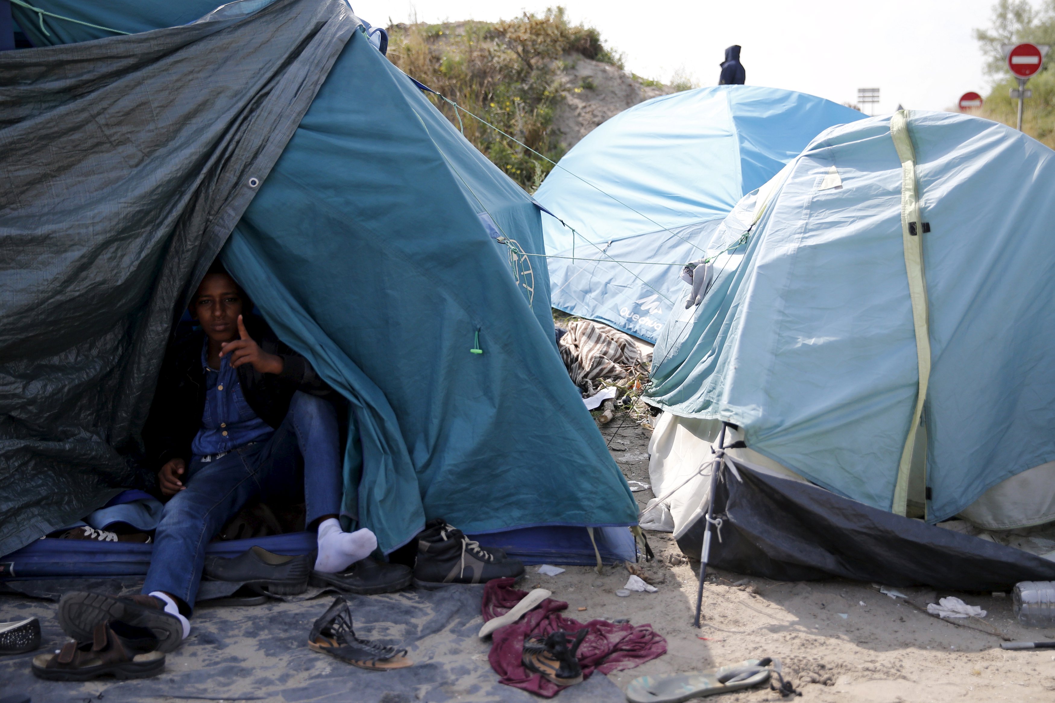 An Ertirean migrant sits in his makeshift shelter in 