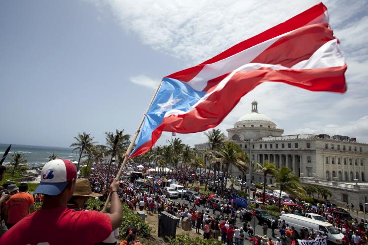 A man waves a Puerto Rico flag in San Juan in May 2015