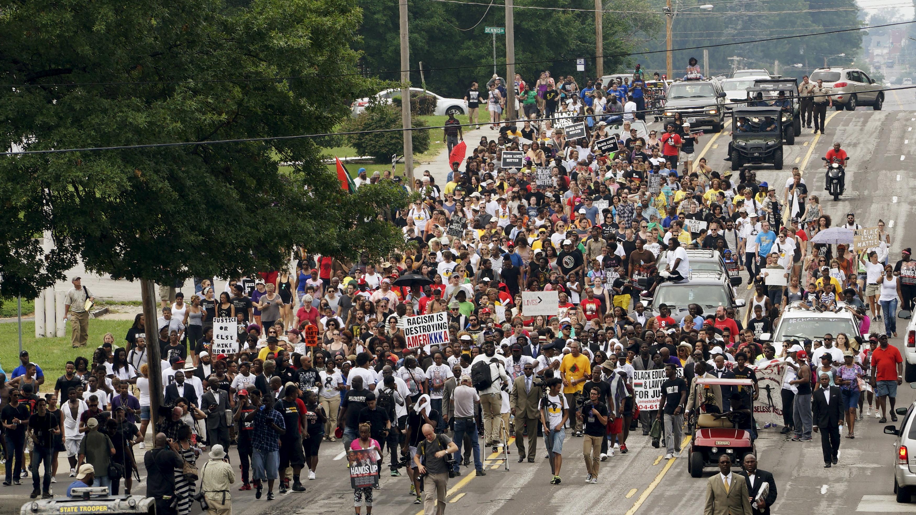 A protest march led by Michael Brown Sr. walks the streets to mark the one year anniversary of the killing of son Michael Brown Jr. in Ferguson, Missouri Sunday.