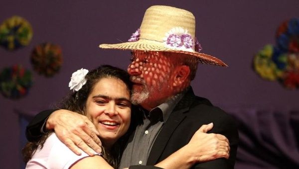 Former President Lula da Silva (R) hugs the secretary of rural worker union Contag, Alessandra Lunas, during the March of the Daisies, Brasilia, Aug. 11, 2015.