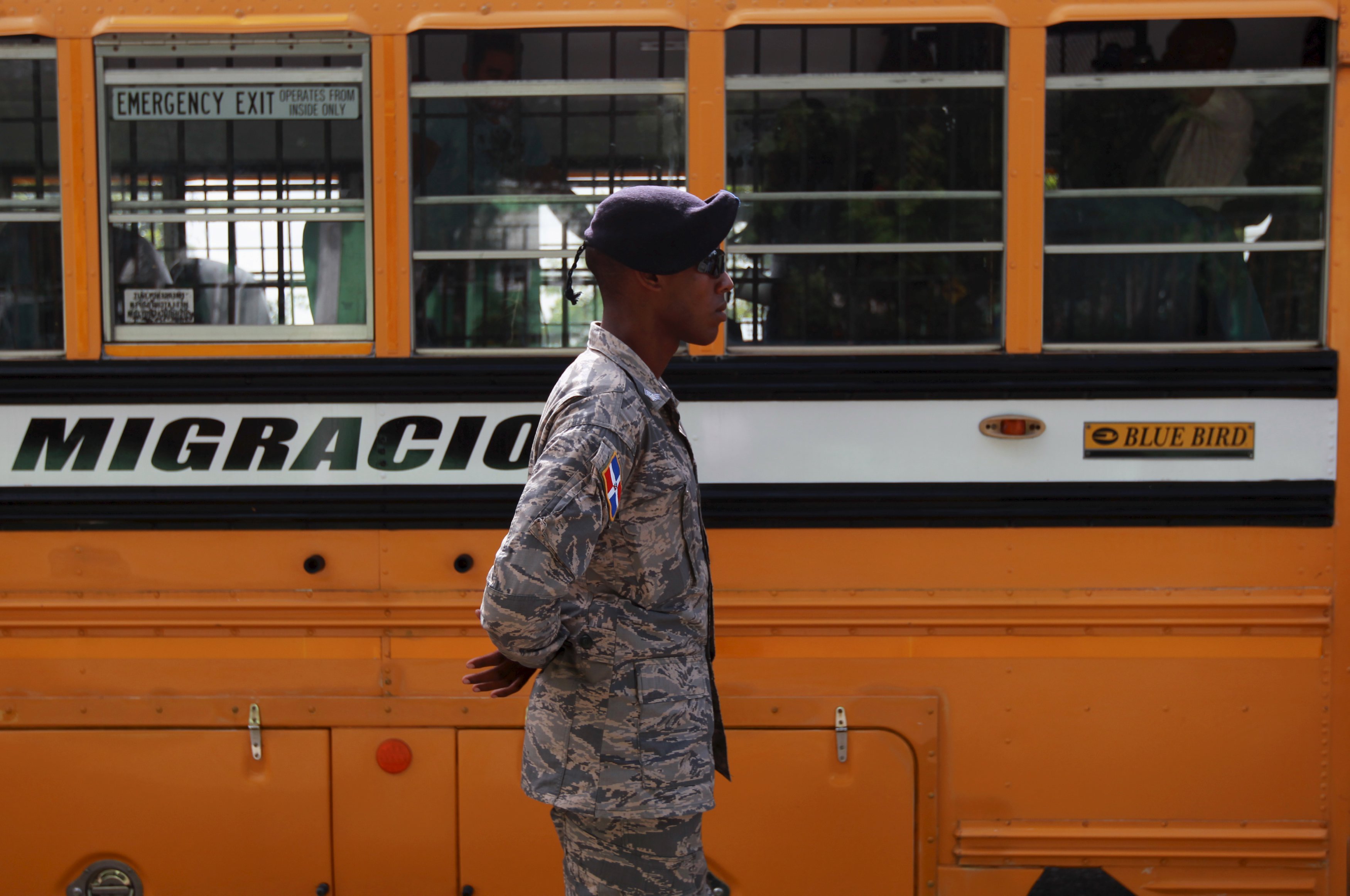 A Dominican soldier guards one of the buses of the National Migration Office in Santo Domingo June 24, 2015.