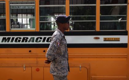 A Dominican soldier guards one of the buses of the National Migration Office in Santo Domingo June 24, 2015.