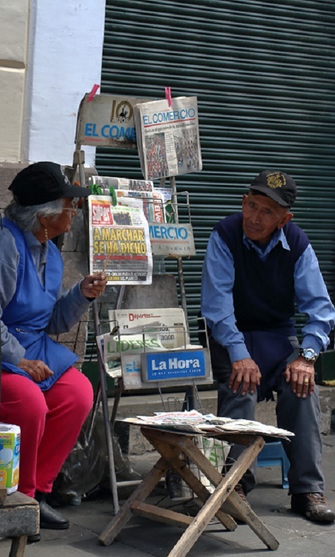 A couple selling newspapers of the day near the demonstrations.