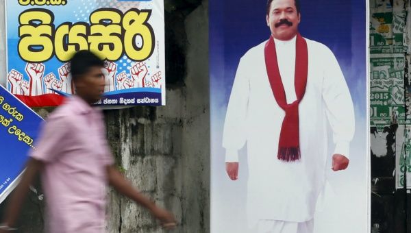 A man walks past a poster of Sri Lanka's former president Mahinda Rajapaksa. The former president is hoping to make a political comeback.