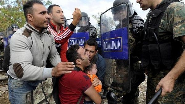 Migrants confront Macedonian police during clashes at the Greek-Macedonian border, August 21, 2015. 