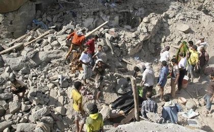 People gather on the rubble of houses destroyed by Saudi-led air strikes in Yemen's central city of Taiz August 21, 2015.