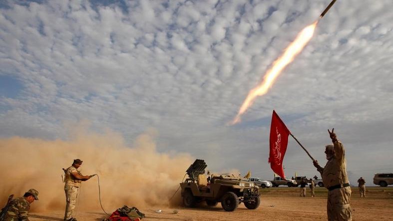 Shiite fighters launch a rocket during clashes with Islamic State group militants on the outskirts.