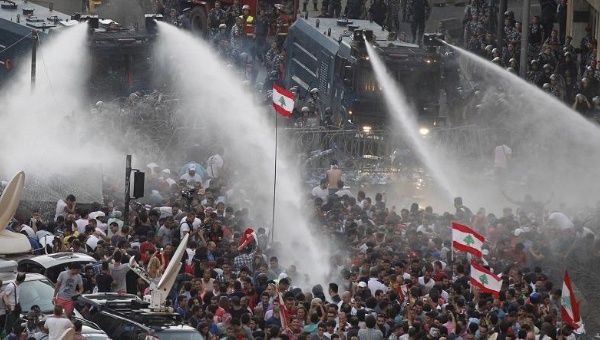 Lebanese protesters are sprayed with water during a protest against corruption and against the government’s failure to resolve a crisis over garbage disposal, near the government palace in Beirut on August 23, 2015.