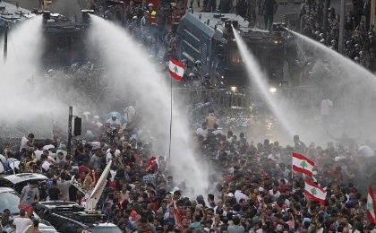 Lebanese protesters are sprayed with water during a protest against corruption and against the government’s failure to resolve a crisis over garbage disposal, near the government palace in Beirut on August 23, 2015.