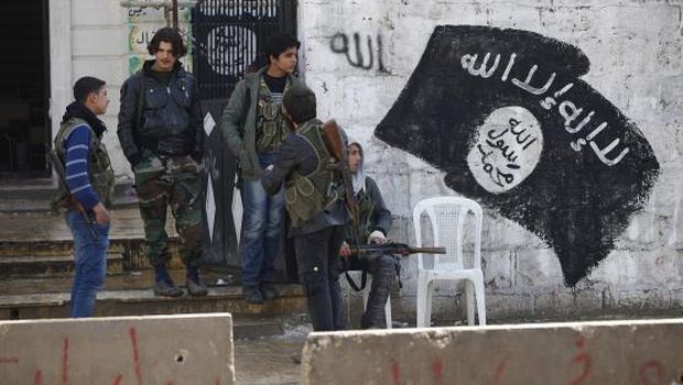 Free Syrian Army fighters stand at a former base used by fighters from the Islamic State group