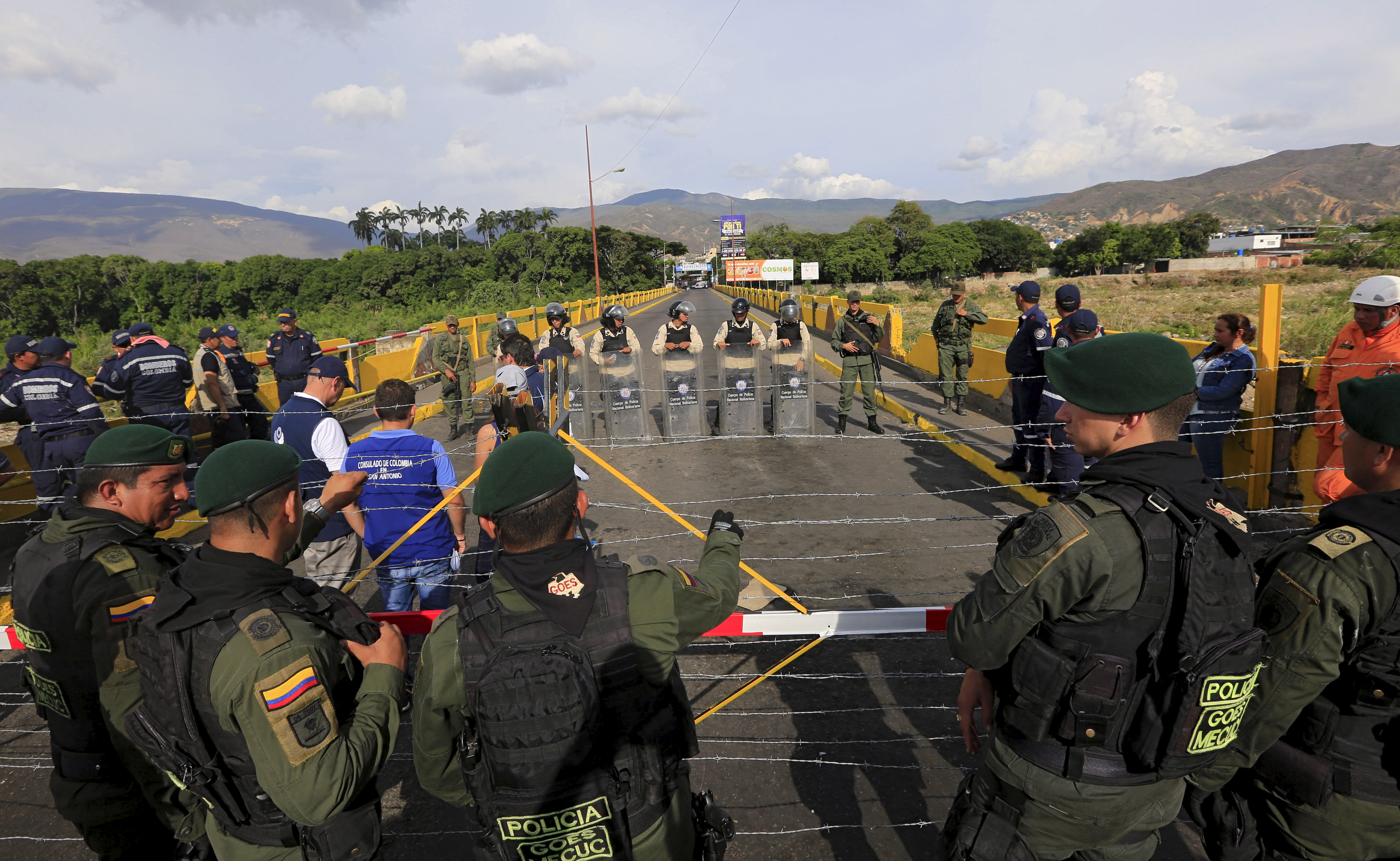 Colombian policemen stand guard in front of the border with Venezuelan policemen Bolivarianos near Villa del Rosario village, August 27, 2015.