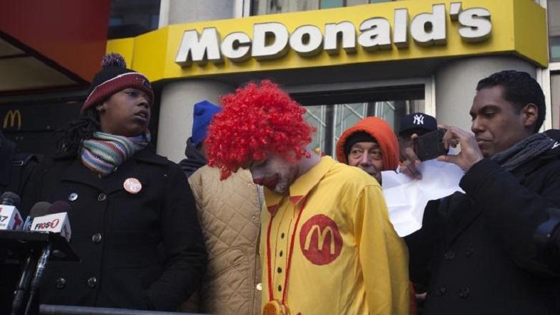 A protester Ben dressed up as Ronald McDonald, only known as Ben, takes part in a protest outside a McDonalds restaurant to demand higher wages for fast food workers in the Manhattan borough of New York March 18, 2014