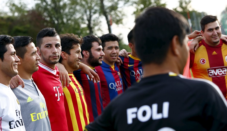 Members of ESV Neuaubing Sports United, Bavaria's first refugee soccer team, stand together before a training session at a football field in Munich-Neuaubing, Germany, Aug. 27, 2015. The team consists of 31 men from Afghanistan, Turkey, Iran, Iraq and Eritrea, and four Germans.