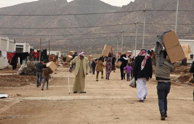 Displaced Iraqi people fleeing violence in the Iraqi town of Sinjar December 7, 2014.
