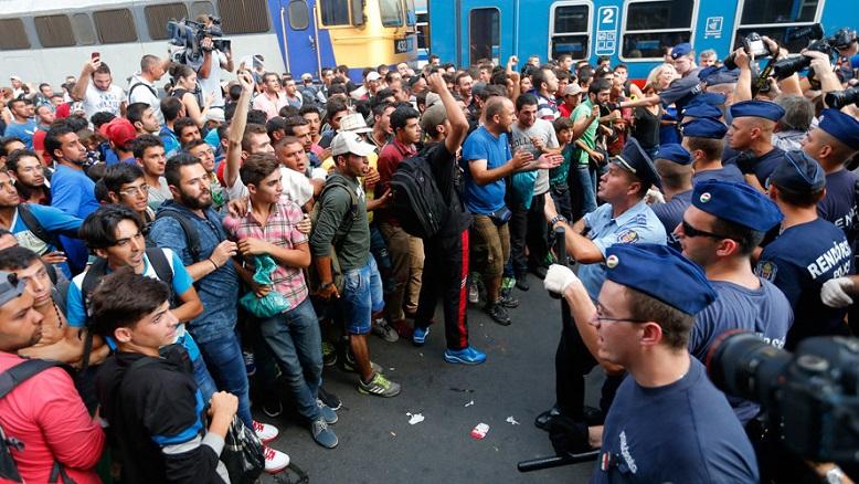 Refugees face Hungarian police in the main Eastern Railway station in Budapest, Hungary, Sept. 1, 2015.