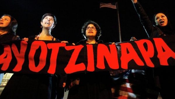 Protesters hold a banner which reads Ayotzinapa in red to protest for the forced disappearance of 43 students
