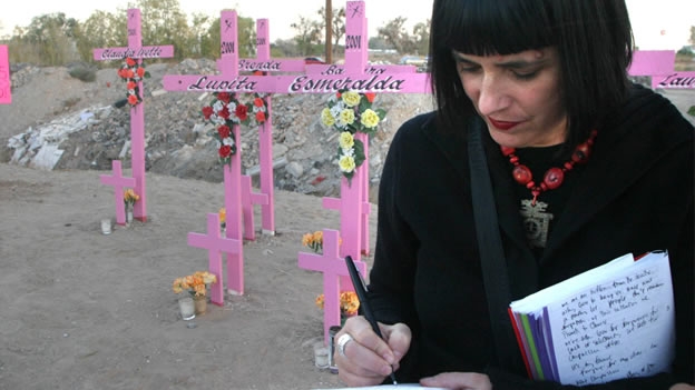 An activist stands in a place with pink crosses with names of dozens of women killed in Ciudad Juarez, Chihuahua state.