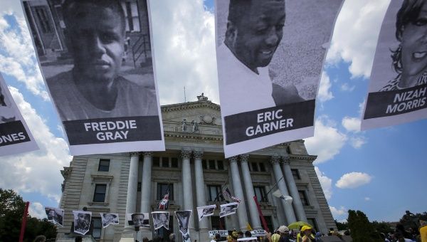 Pictures of Eric Garner, Freddie Gray and Nizah Morris are seen while people take part in the Million People's March Against Police Brutality, Racial Injustice and Economic Inequality in Newark, New Jersey in this July 25, 2015.