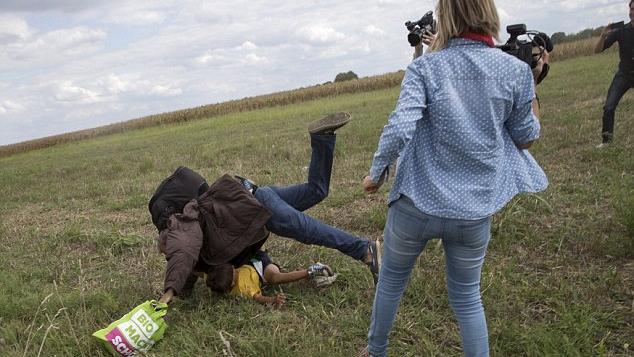 Camerawoman Petra László, working for N1TV, is seen in the this photo just seconds after she tripped the refugee carrying his child.
