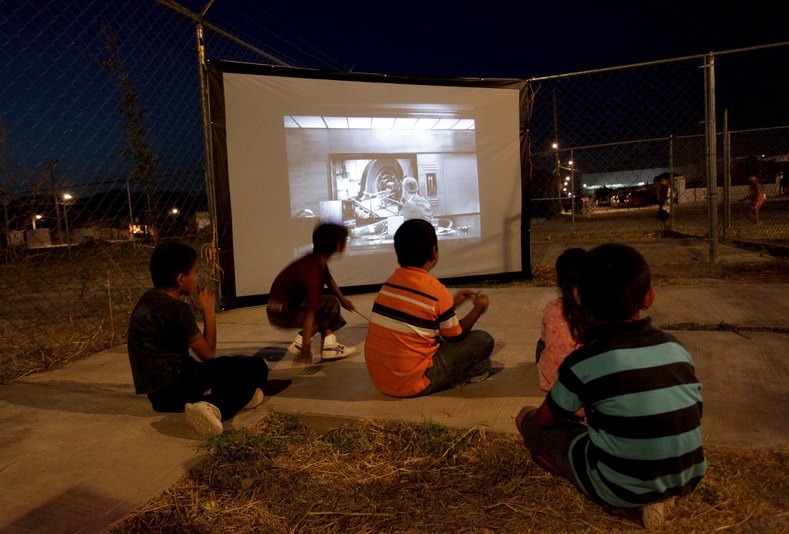 Children watch a movie projected by the Cinecleta, Moviebike, at a park in Saltillo, Mexico, Sept. 6, 2015.